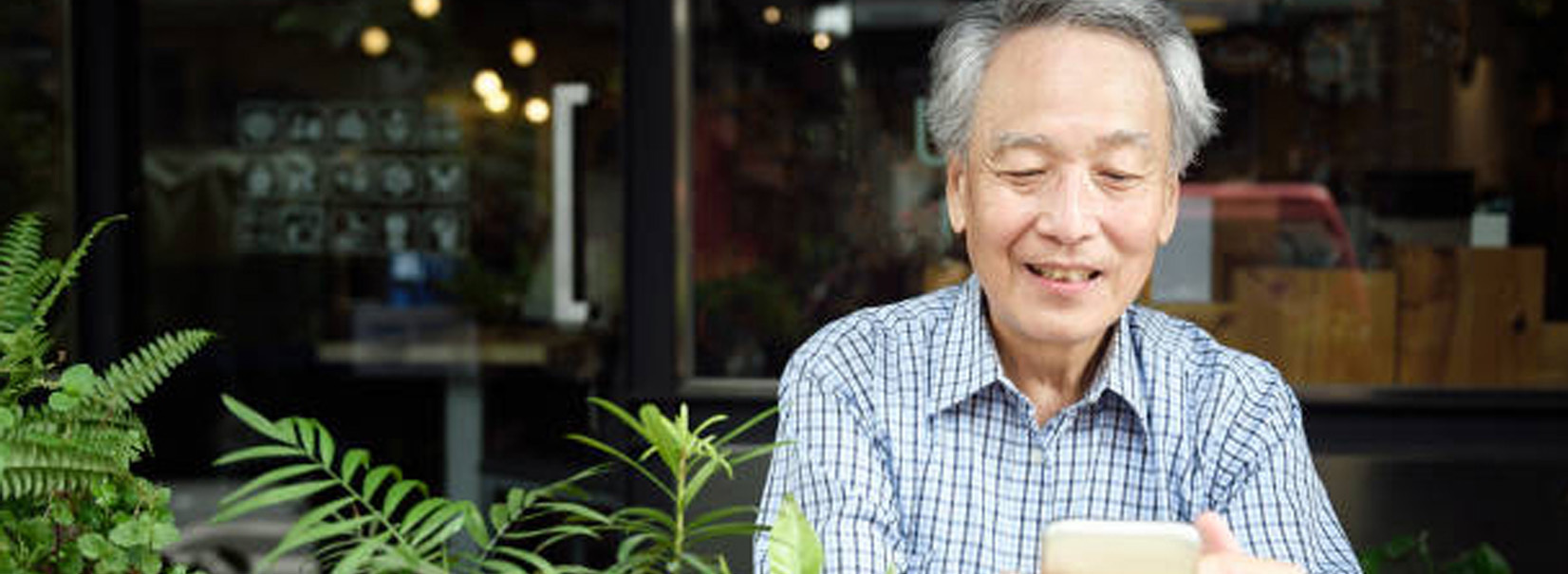 man looking at his phone in a cafe