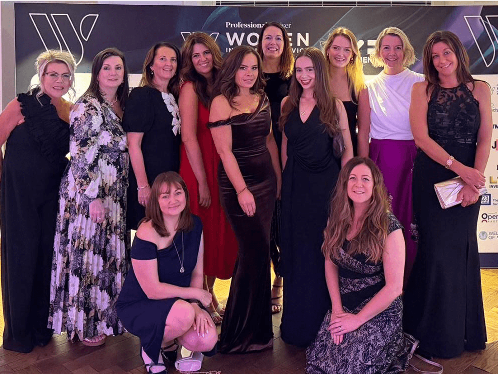 Image of a group of women in cocktail dresses at an awards ceremony