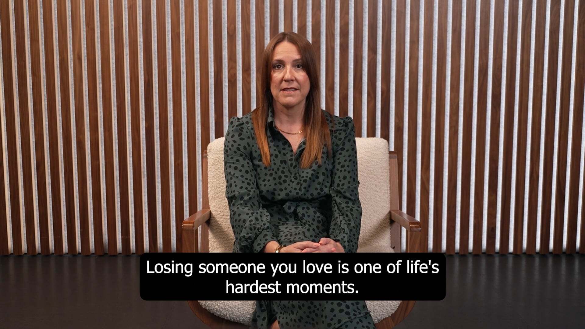 Women sitting on a chair speaking with sub titles
