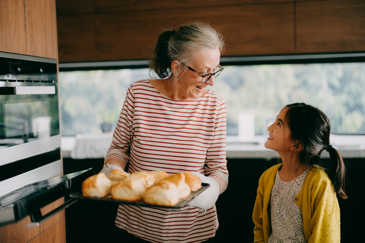 Grandmother and granddaughter baking at home