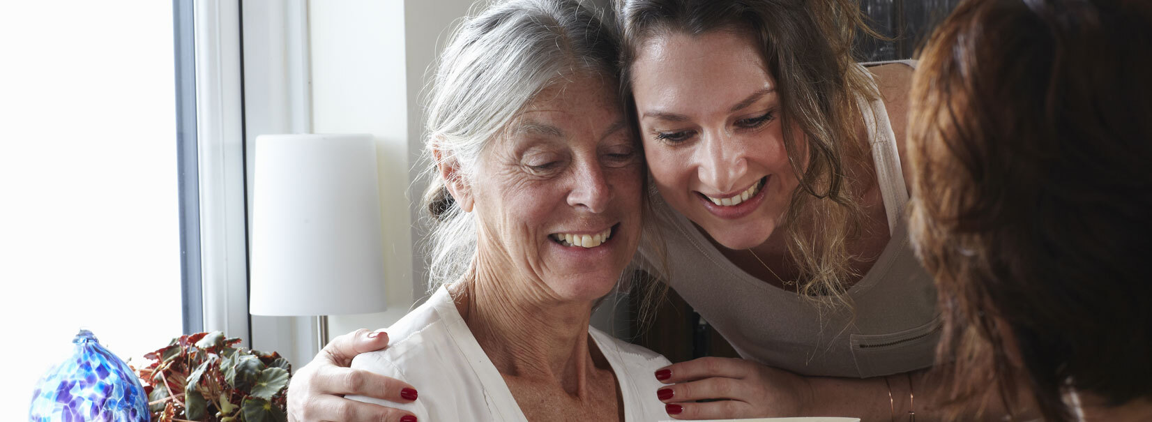 older women and younger women looking at card