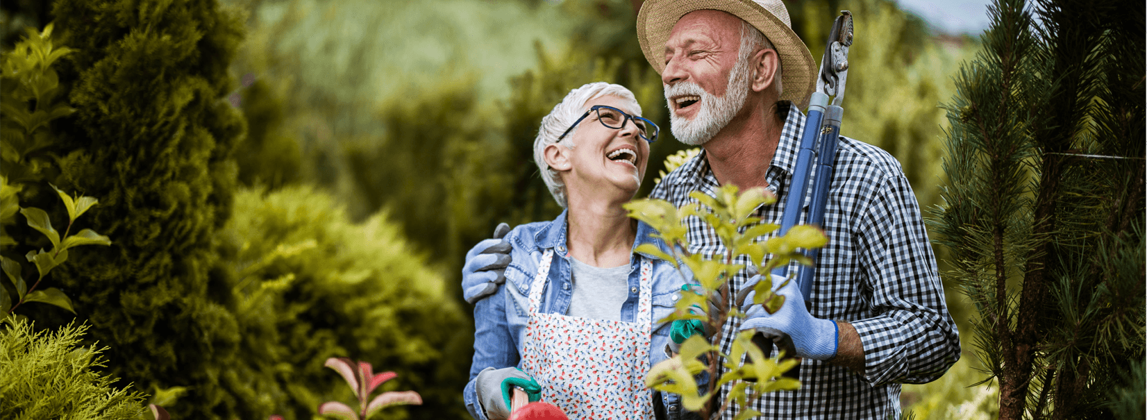 senior couple smiling whilst gardening