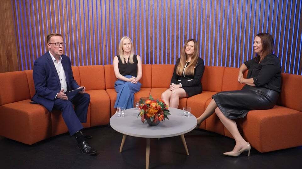 Man and three women sitting on a sofa talking